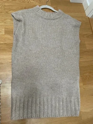 Beige stickad väst med slits