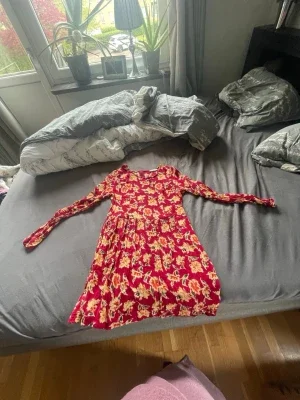 Röd blommig långärmad klänning
