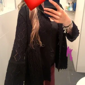 Svart stickad kofta med mönster