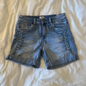 Blå jeansshorts med nitar och uppvik