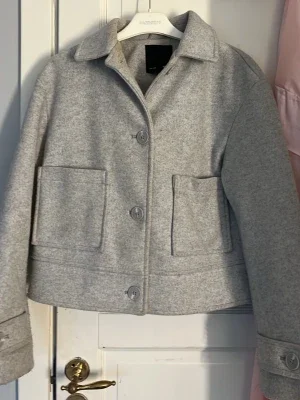 Ljusgrå ullkappa med stora fickor