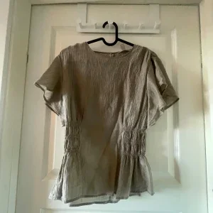 Beige blus med rynkade detaljer