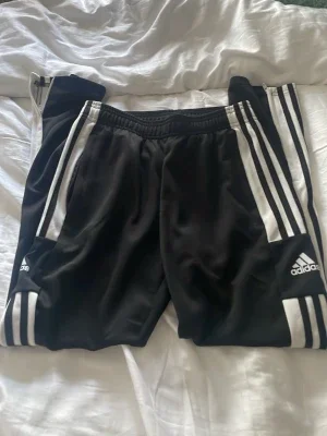Svarta Adidas träningsbyxor med vita ränder