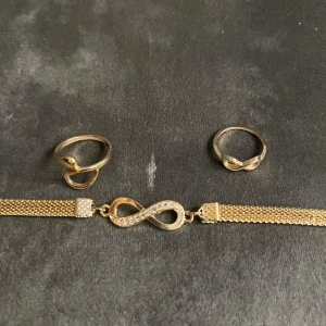 Guldigt smyckeset med infinitytema