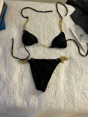 Svart bikini med guldkedjor