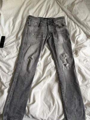 Grå slitna jeans från replay nk