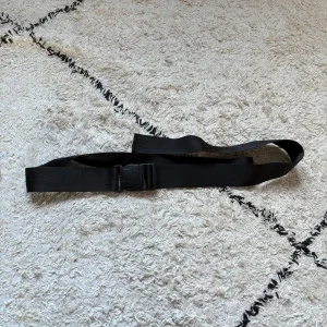 Svart syntetbälte med plastspänne