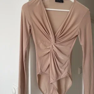 Beige omlott bodysuit från Club L