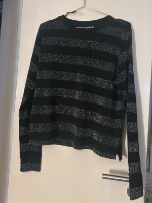 Svart glittrig randig stickad tröja