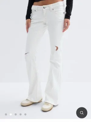 Vita bootcut jeans med slitningar