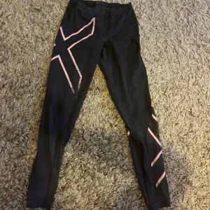 Svarta 2XU tights med rosa detaljer