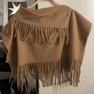 Beige poncho med fransar