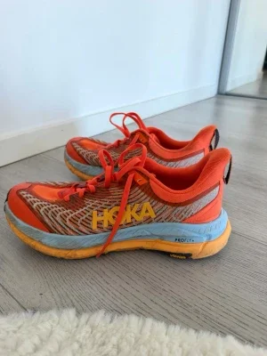 Orange Hoka sneakers med blå sula