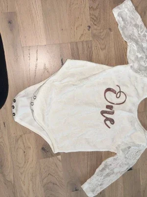 Vit spetsbody med glittertext Vit body