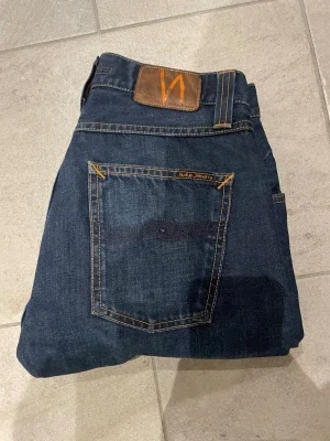 Mörkblå raw denim jeans från Nudie Jeans