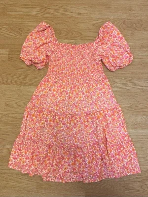Blommig rosa orange klänning med puffärm midsommar sommar