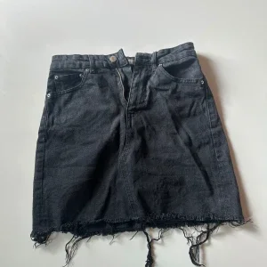Svart jeanskjol med fransad kant
