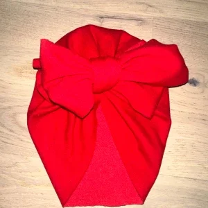 Röd turban med stor rosett Röd mössa