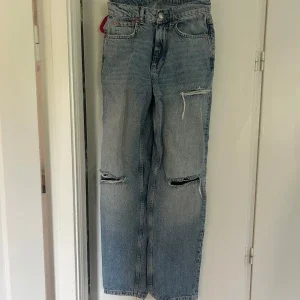 Ljusblå slitna jeans med raka ben