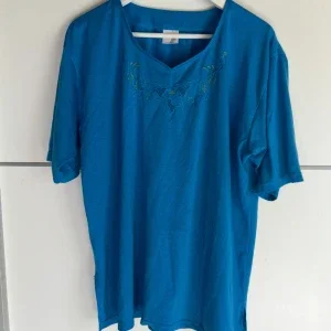 Blå blus med broderi och v-ringning