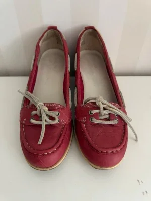 Röda seglarskor med vita snören