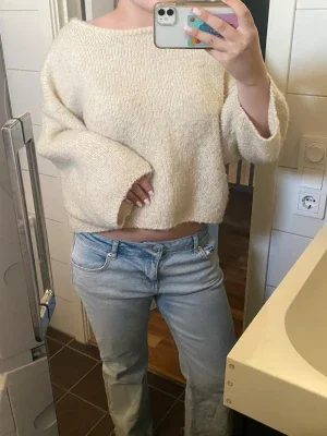 Beige stickad tröja med vida ärmar