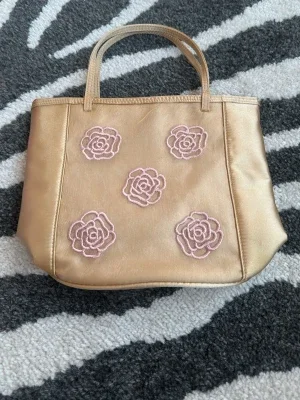Beige handväska med rosa blommor