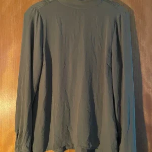 Grön blus med spetsdetaljer