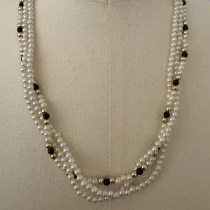Pärlhalsband med svarta och guldiga detaljer