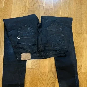 Svarta jeans med slitningar