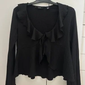 Svart volangblus med knyt från H&M