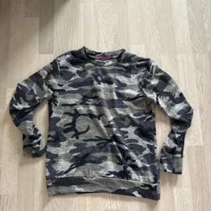 Camouflage mönstrad tröja och byxor
